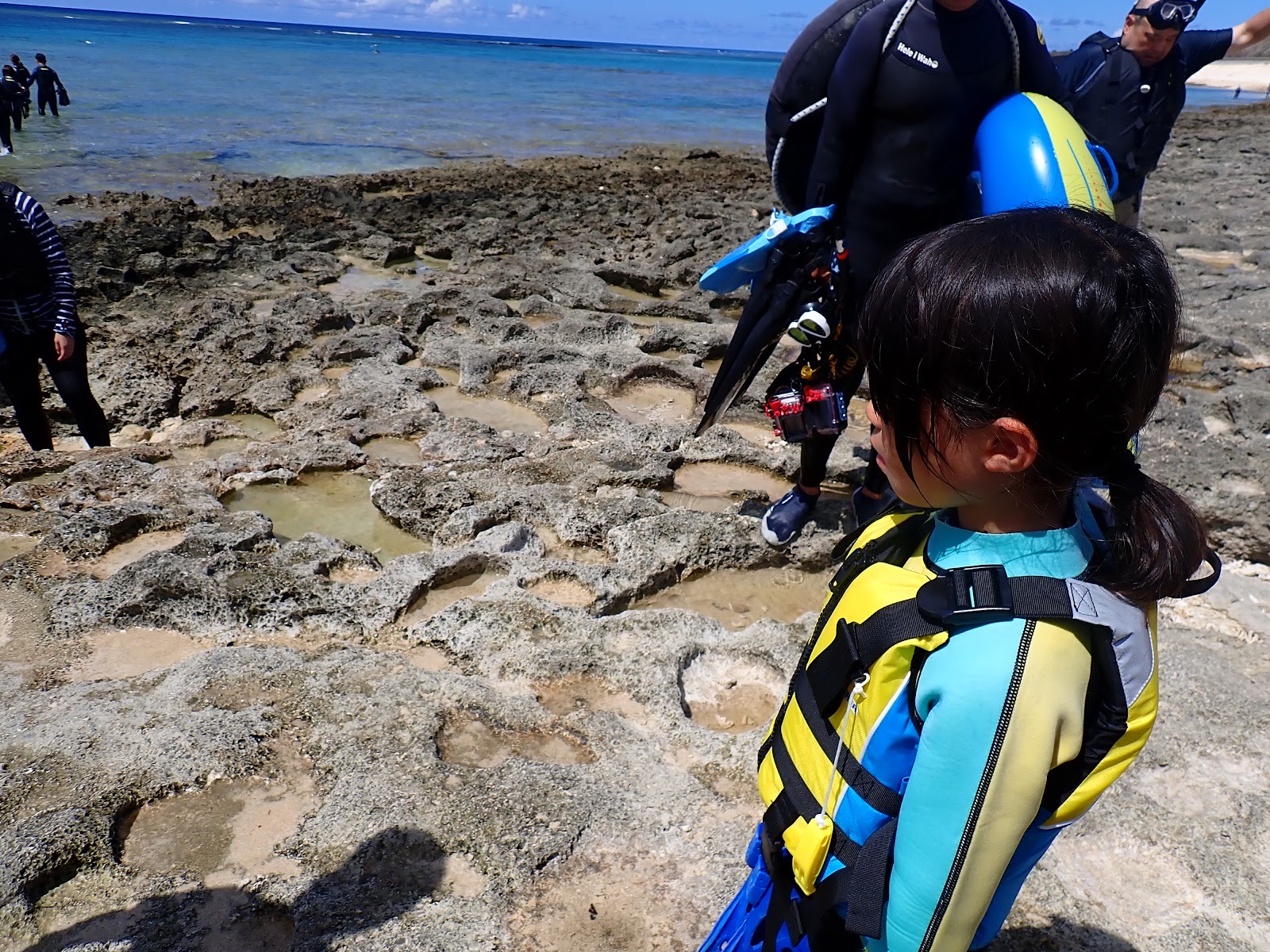 岩場を海へ進む参加者