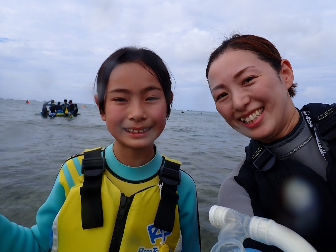 水辺でガイドと子供が笑顔でカメラに向かってポーズをとるセルフィーショット