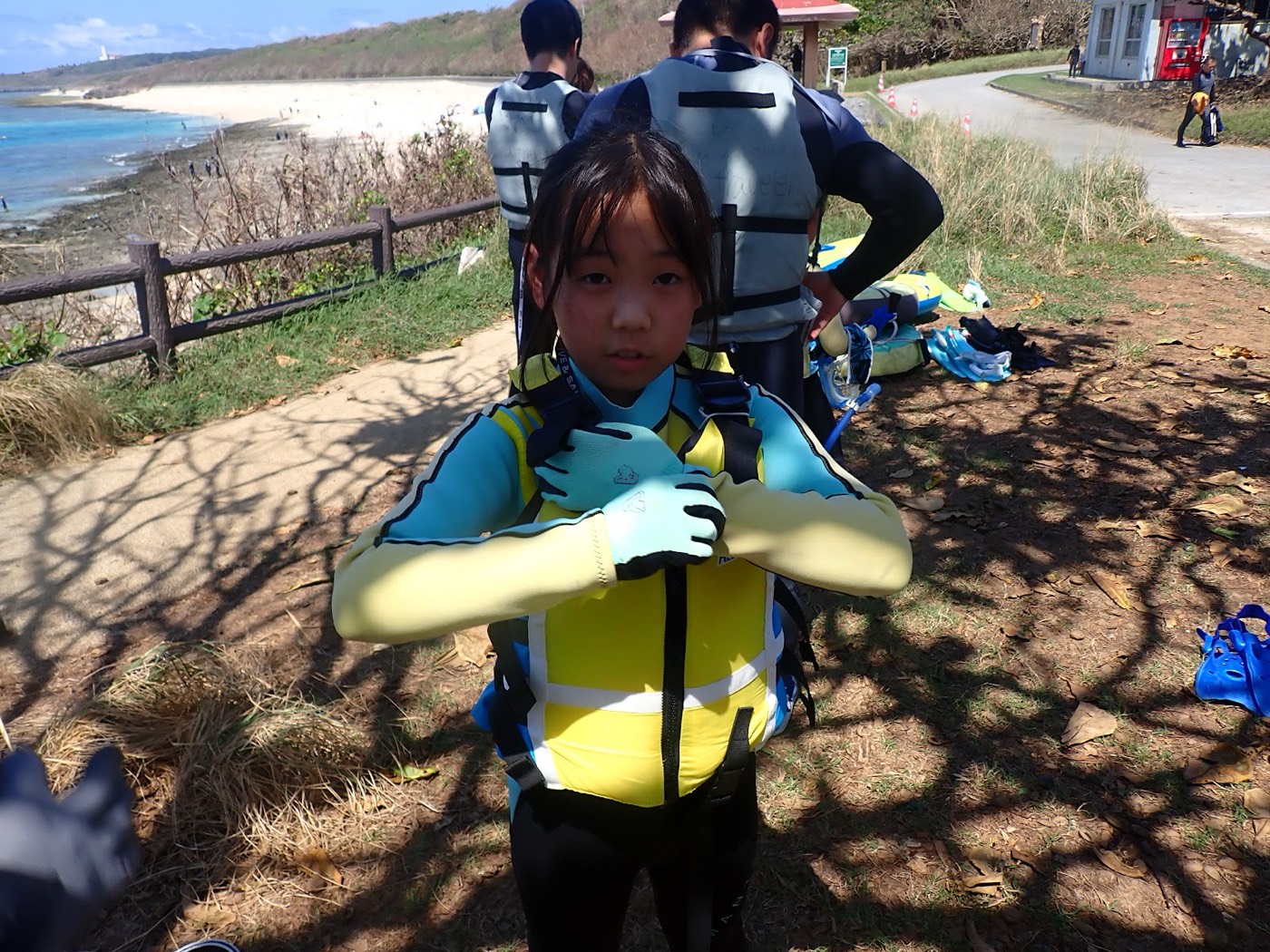 海岸でウェットスーツを着て笑顔でポーズをとる小さなお子様