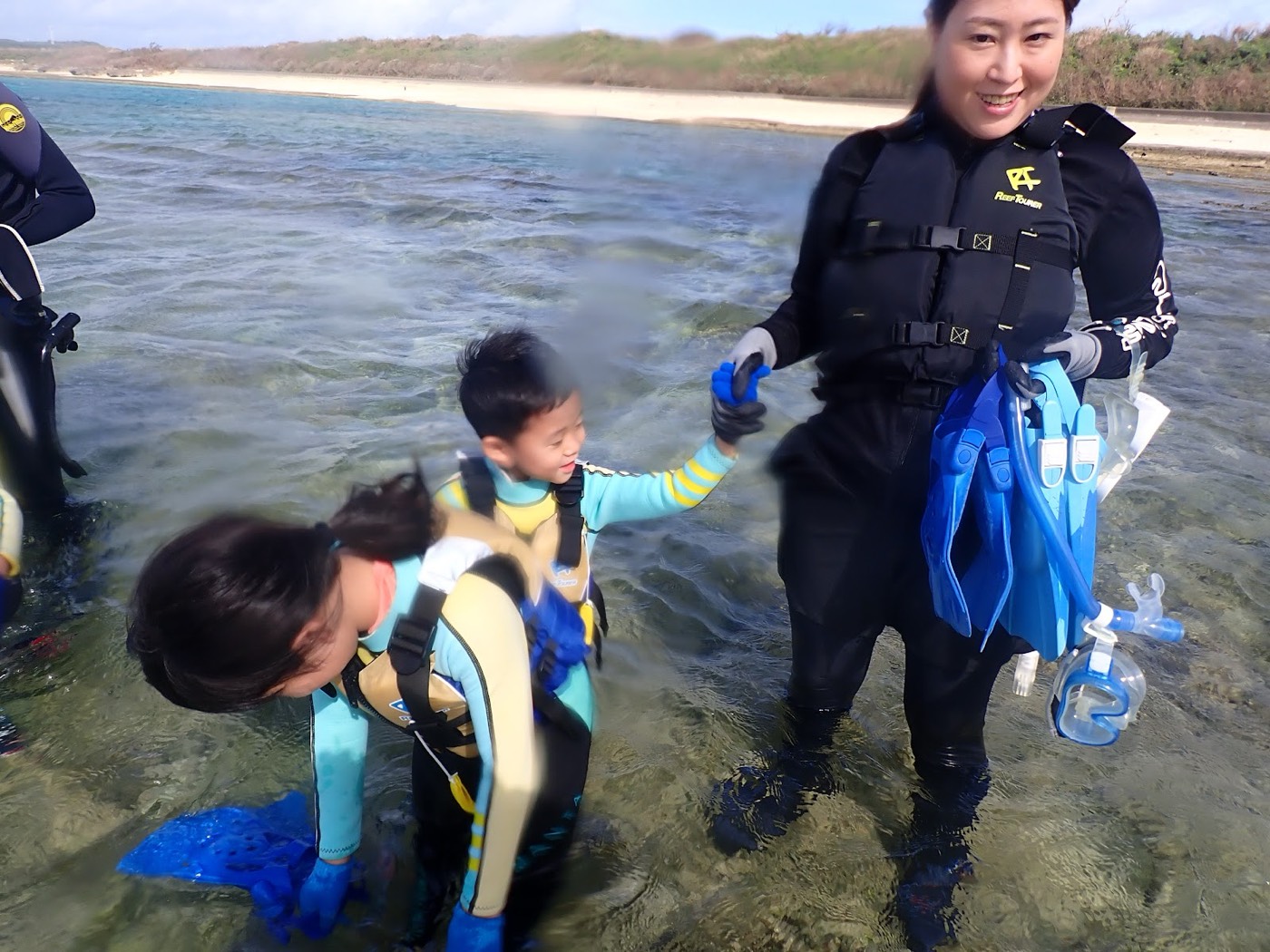 水中でフロートに掴まり、顔を見合わせて話す子供たちの様子
