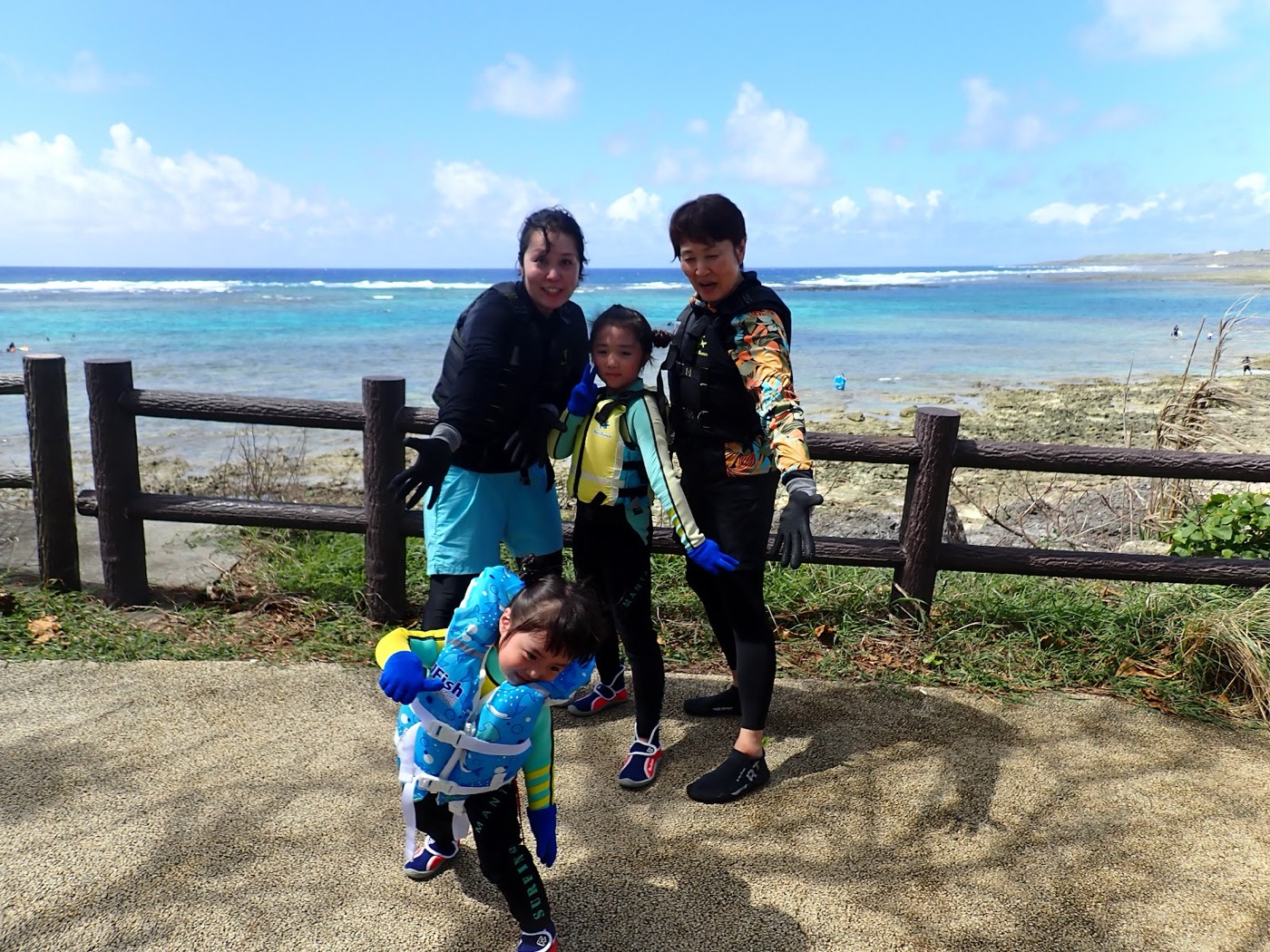 浅瀬で浮き具とともに並ぶ大人のグループの天然水族感ある一枚
