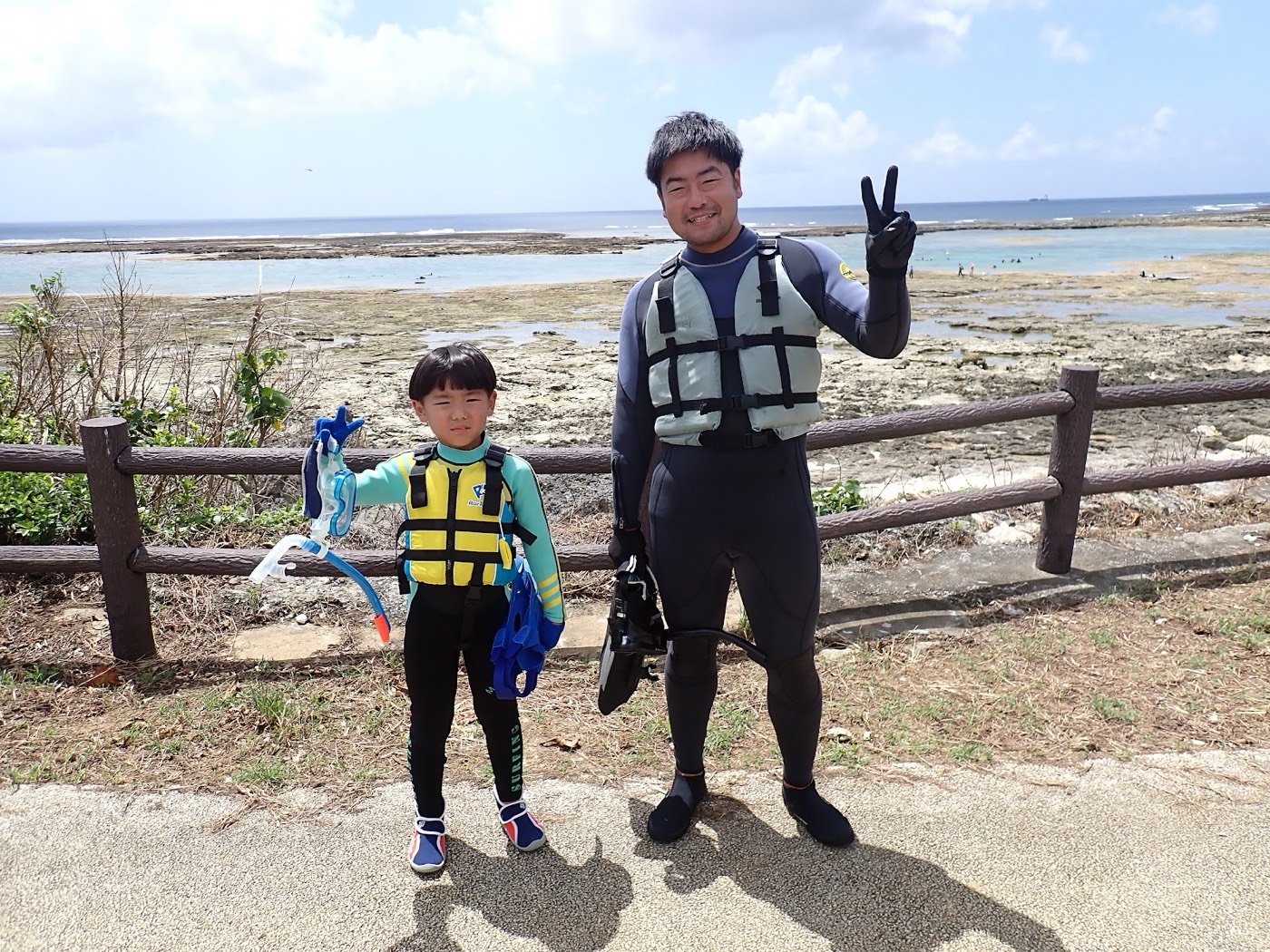 天然水族感で紹介する、ある海を背景に参加者がウェットスーツ姿で並ぶ記念写真