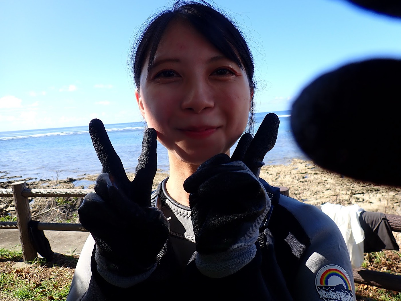 糸満市の海岸で自然体験シュノーケルの準備をする参加者とガイド。フロートを手に器材を確認する様子