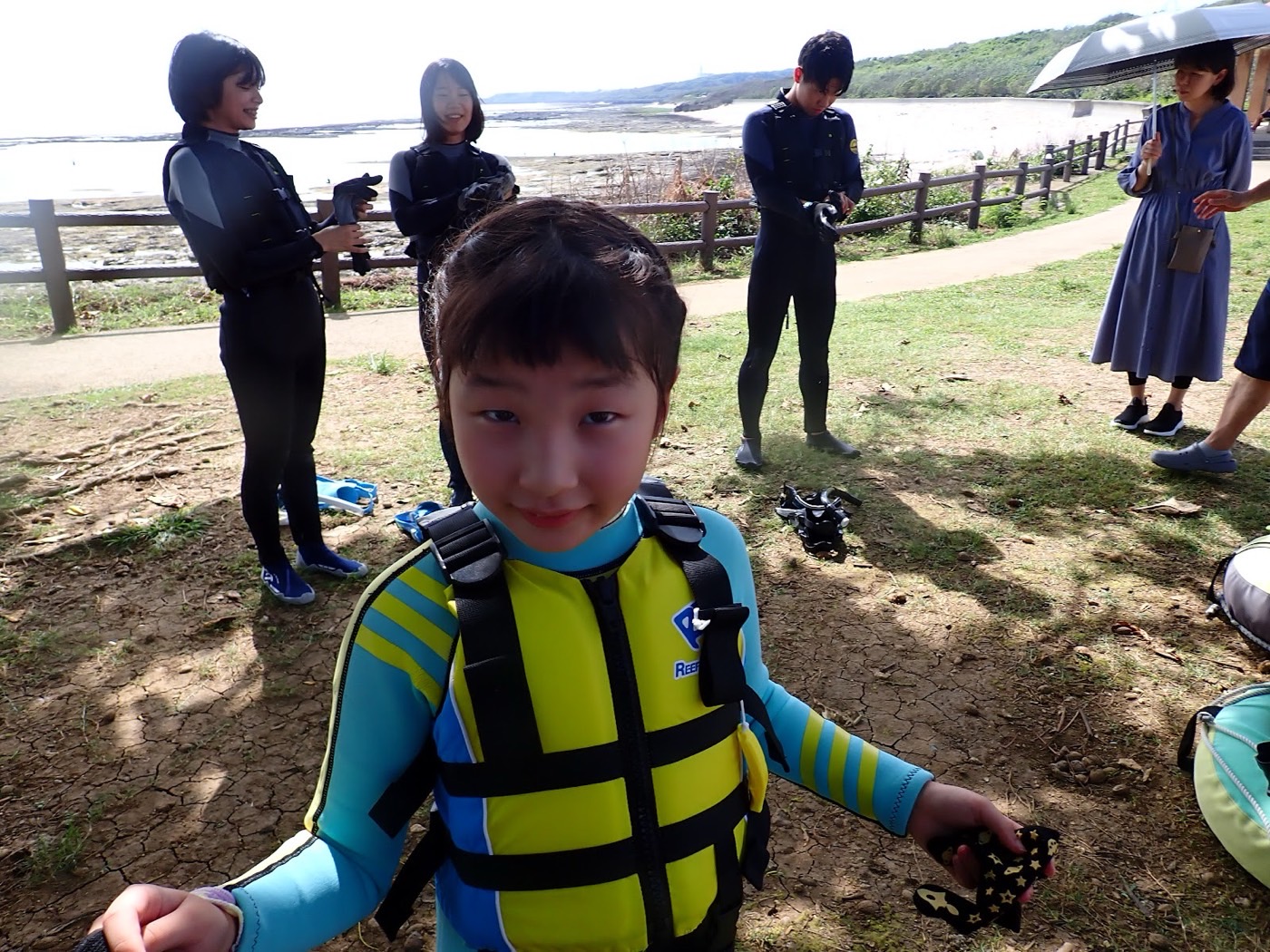 天然水族感を感じる海辺でライフジャケットを着用する子供