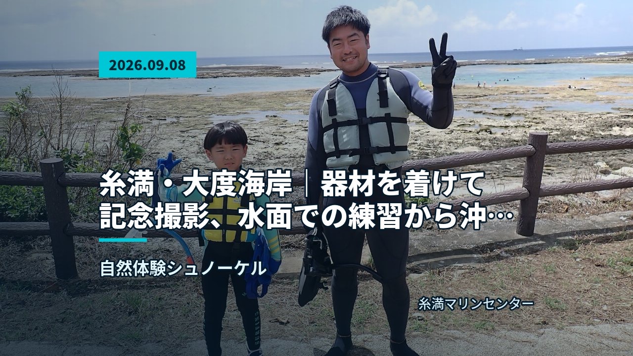 ある海を背景に参加者がウェットスーツ姿で並ぶ記念写真