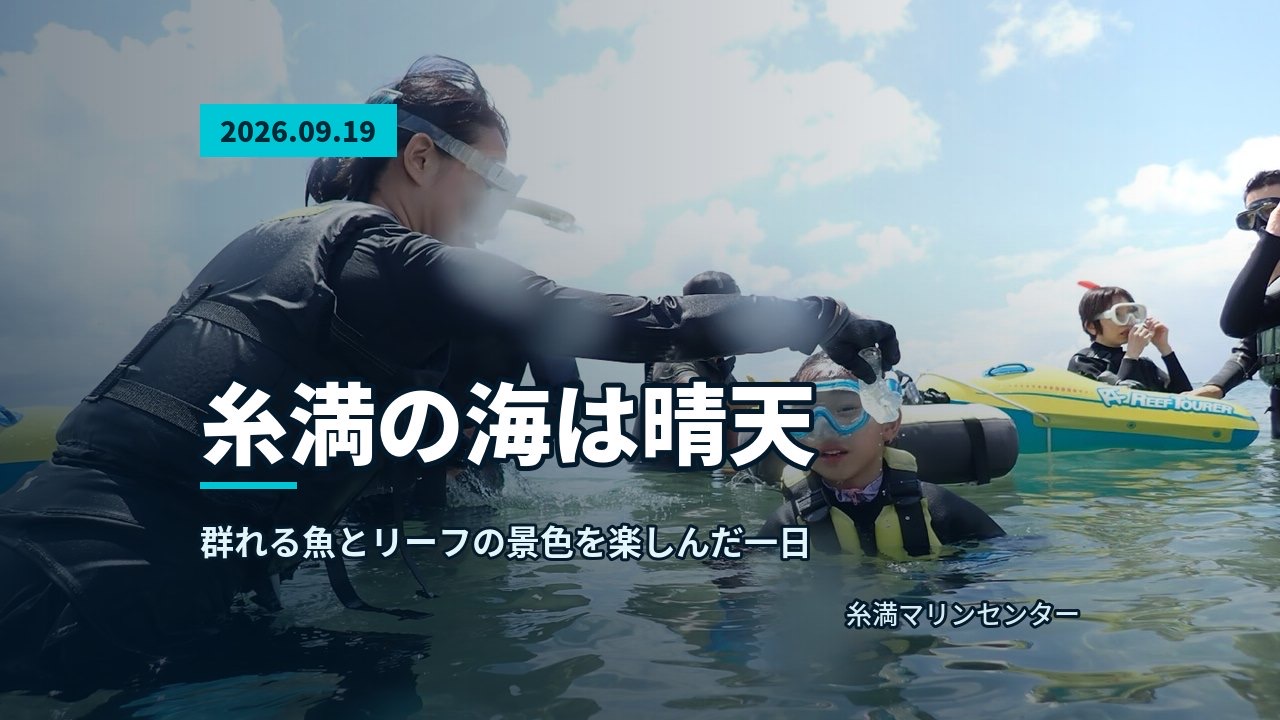 水面に立つ参加者が両手でピースサインをしながら笑顔を見せる、背後に広がる海と空、ビーチ