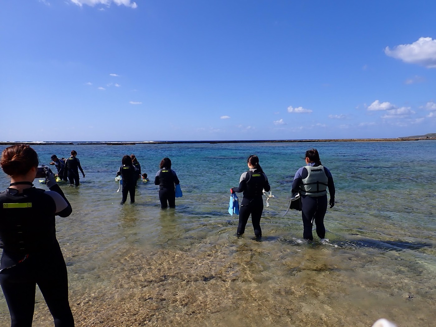 浅瀬で水慣れをしながら海へ入っていく参加者たち