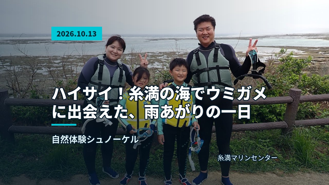 海岸の岩場を背景に、ウェットスーツを着て笑顔でピースする参加者