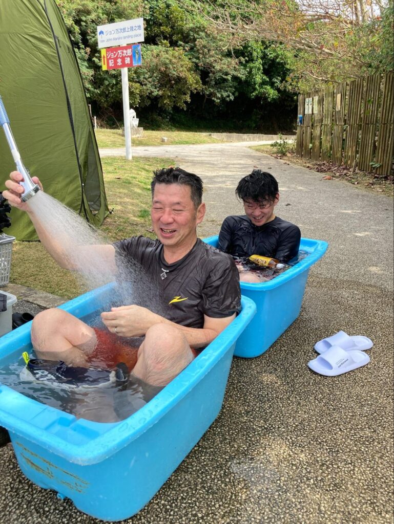 タライに浸かりながら簡易温水シャワーで海水を流すゲスト